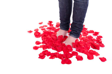 A young beautiful girl is stand in the middle of rose petalsの写真素材