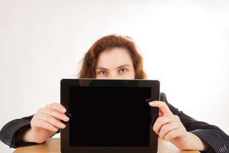 A young woman holds her tablet computer in the camera