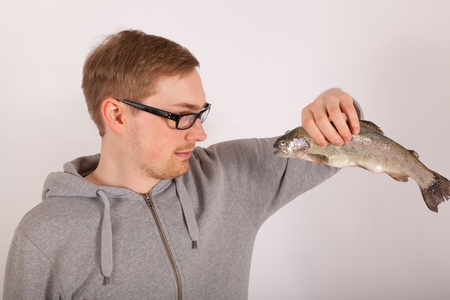 A young man has a fish in his handの写真素材