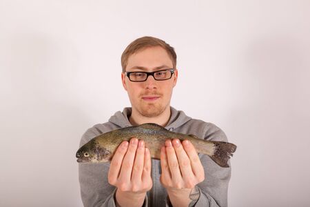 A young man has a fish in his handの写真素材