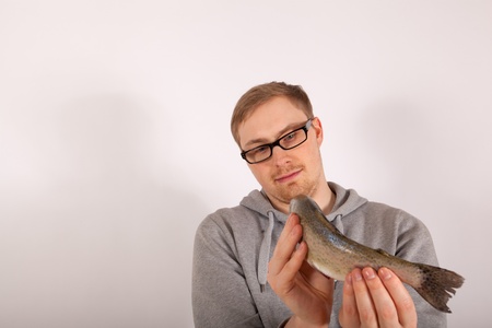 A young man has a fish in his handの写真素材