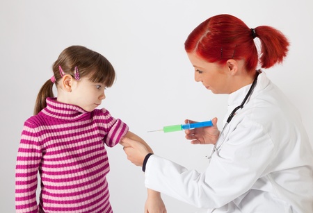 The young pediatrician inoculating a small girlの写真素材