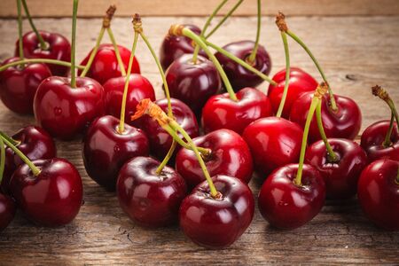Cherries on wooden table with water drops macro backgroundの写真素材