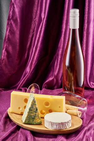 Set of various wines and Camembert cheese, blue cheese and Gouda cheese in wooden plate with copy spaceの写真素材