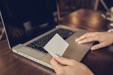 Attractive woman with credit card and laptopの写真素材