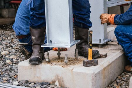 men working with safety equipment, placing columns, various tools