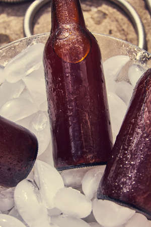beer bottles with drops on ice cubes, brown bottlesの写真素材