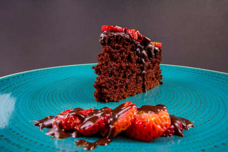 chocolate cake with strawberries in turquoise dish, closeupの写真素材