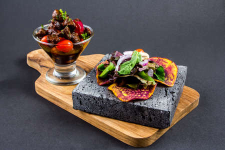 Sliced grilled beef barbecue Striploin steak and salad with tomatoes and arugula on cutting board close-upの写真素材