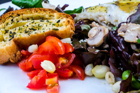 Portion of lasagna garnished with salad greensの写真素材