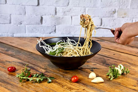 pasta with chicken with rice noodles on a black plate, leafの写真素材