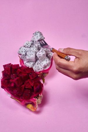 Red dragon fruit Set with appetizing serving Isolated on pink background. Top view, handの写真素材