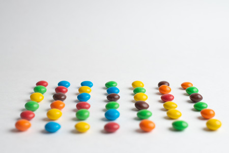 Colorful chocolate candies on the white background