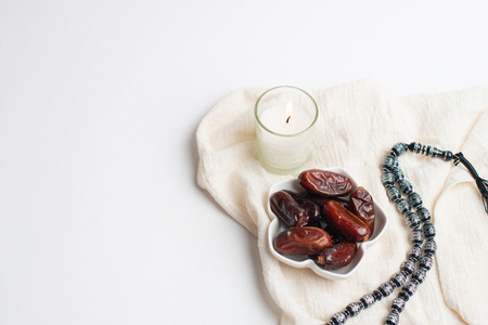 Ramadan Kareem Festival, Dates at bowl with rosary and candle the white isolated backgroundの写真素材