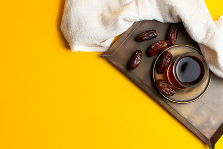 Ramadan Kareem Festival, Tasty dates at bowl with a cup of black tea on yellow backgroundの写真素材