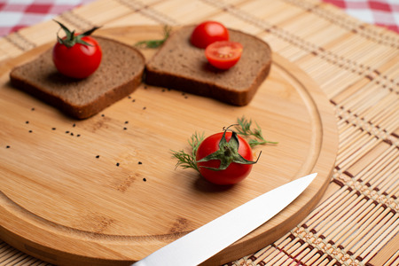 Black bread with tomato on the wooden backgroundの写真素材