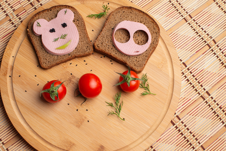 Sausage with black bread and tomate for lunch, Black bread with tomato on the wooden background, Tomates with black breadの写真素材