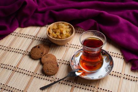 Homemade oatmeal cookies with a cup of tea on old wooden background, A cup of tea with raisin, a cup of tea with chocolateの写真素材
