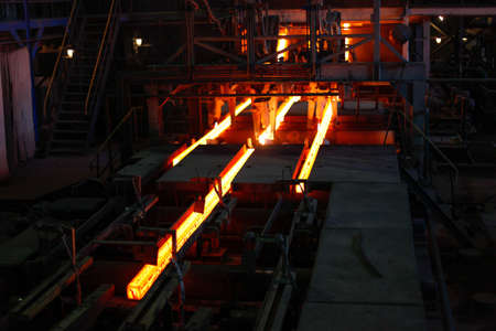 Red hot steel metal billets after molten steel casting.  Continuous casting machine. Background of the blacksmith and metallurgical industry.の写真素材