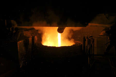 Hot steel pouring in steel plant. Molten metal poured from ladle. Metallurgical production, heavy industry, engineering, steelmaking.の写真素材