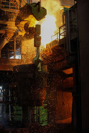 Steel production in electric furnaces. Sparks of molten steel. Electric arc furnace shop EAF. Metallurgical production, heavy industry, engineering, steelmakingの写真素材