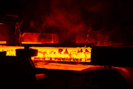Red hot steel metal billets after molten steel casting. Background of the blacksmith and...