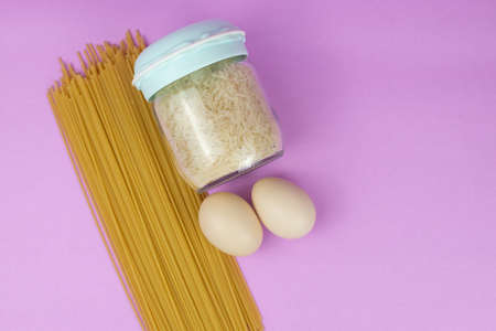 Food stock for quarantine isolation period on purple background. Rice, egg, spaghetti. Food delivery, Donation. Copyspaceの写真素材