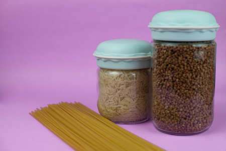 Food stock for quarantine isolation period on purple background. Rice, buckwheat, spaghetti. Food delivery, Donation. Copyspaceの写真素材