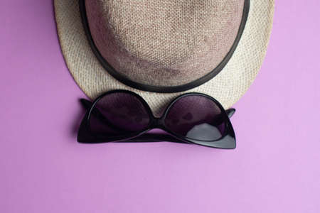 Summer accessories, panama hat and sun glasses on violet background. Summer vacation and sea concept. Copyspace for textの写真素材