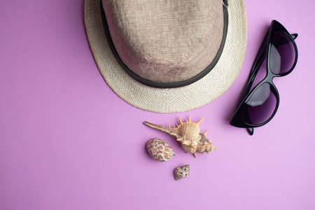 Summer accessories, shells, hat and sun glasses on pink background.の写真素材