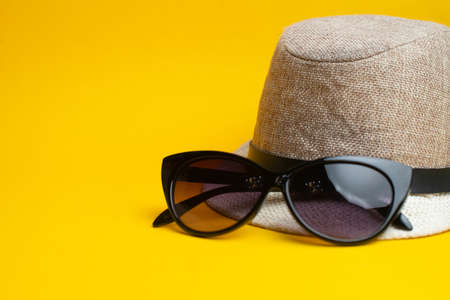 Summer accessories, hat and sun glasses on yellow background. Summer concept.の写真素材