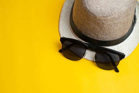 Summer accessories, hat and sun glasses on yellow background. Summer and sea concept.の写真素材