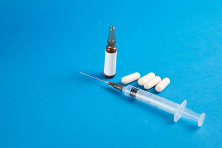 Coronavirus 2019-nCoV outbreak. Pills and syringe on a blue background. Pills and drug, care during illness.の写真素材