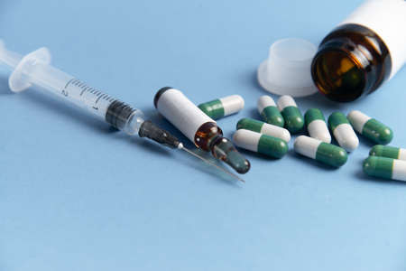 Coronavirus 2019-nCoV outbreak. Pills and syringe on blue background. Pills and drug, care during illness.の写真素材