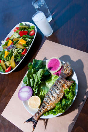 Sea bass fish, healthy vegetable salad and Turkish raki from Turkish tavern aka tavern