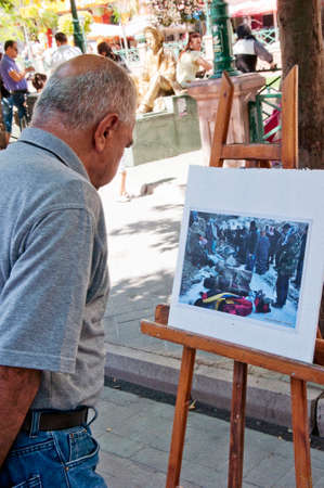 Old man looking the photos in open photograph exhibition in Eskisehir, Turkeyのeditorial素材