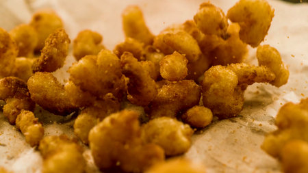 crispy fried onion rings on parchment paper, close-upのeditorial素材