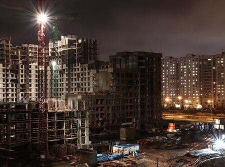 Construction site at night. Building under construction lighted by bright spotlightsの写真素材