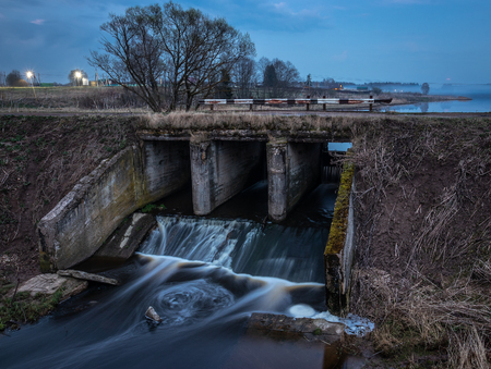 Old river dam in the evening. Water blurred by long exposureの写真素材
