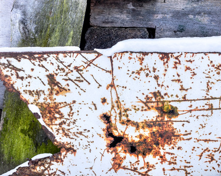 Scratched metal sheet and rusty holes background. Wooden board covered with green moss. Texture for designの写真素材