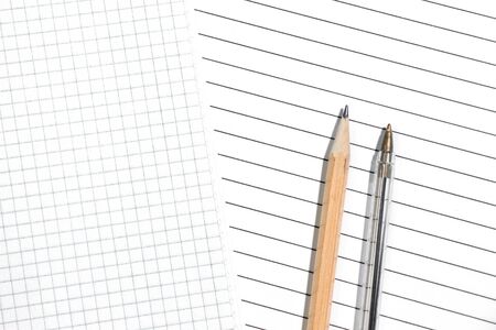 Close-up of checkered and striped sheets with pencil and pen. The choice of the two options. Top view, copyspaceの写真素材