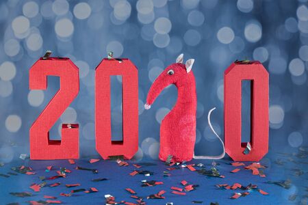 New year 2020 composition with red geometric numbers and confetti against bokeh blue background. Toy rat in the form of figure 2の写真素材