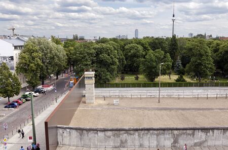 Berlin, Germany - June 10th, 2012: A section of the original east-west Berlin border and walls, viewed from the tower of the Berlin Wall Documentation Center in Bernauer strasse. Tourists and locals are walking on the pavement next to the wall.のeditorial素材