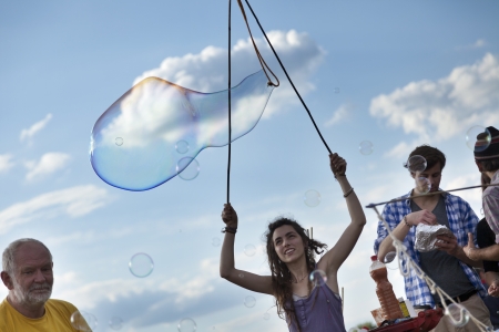 Berlin, Germany - June 10th, 2012: A group of people making giant soap bubbles on an early summer...