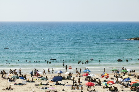 Tel-Aviv, Israel - August 18th, 2012: High angle view of the beach in Tel-Aviv, packed with people on a hot summer day.のeditorial素材