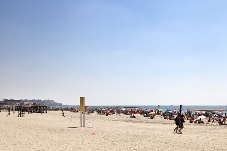 Tel-Aviv, Israel - August 18th, 2012: Crowds of people vacating on the beach in Tel-Aviv on a hot summer day.のeditorial素材