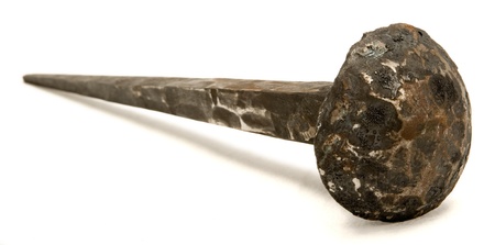 A close up of a very big iron nail, as viewed from beside it. Isolated on white background.の写真素材