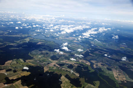 Aerial view of clouds over green land features 