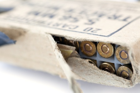An old and torn cardboard pack containing 20 5.56mm tracer cartridges, isolated on white background.の写真素材