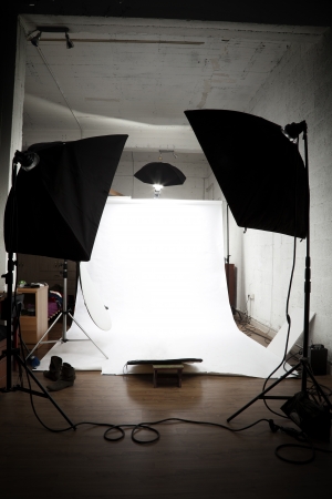 Loft turned into a photographer studio ready for action. White paper limbo surrounded by lighting equipment.の写真素材